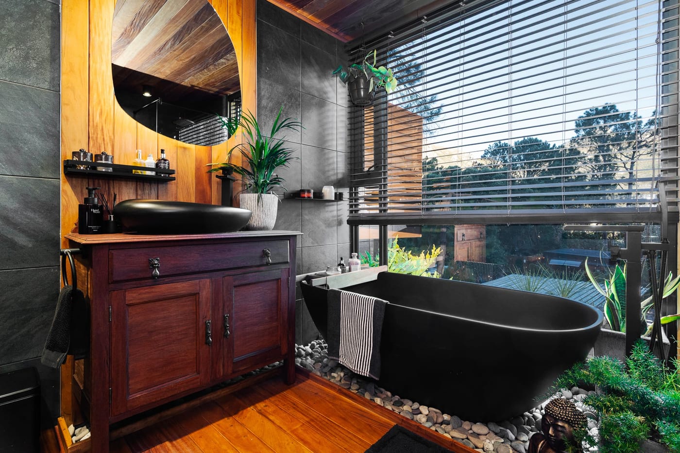 The ensuite — antique timber vanity, black stone basin and freestanding bath on pebbles