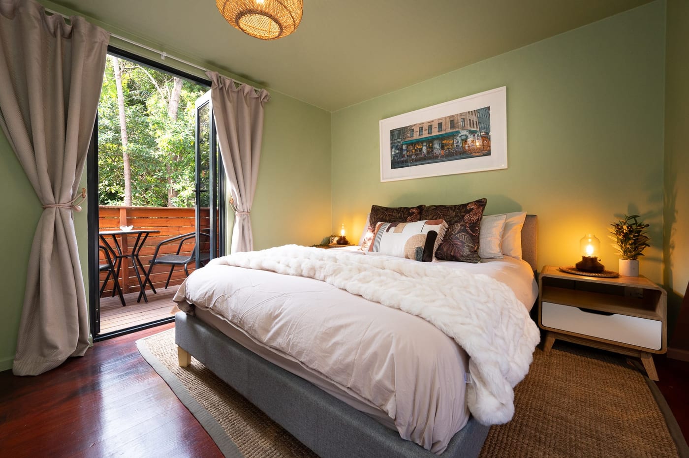 The bedroom door open to a private balcony and its bistro table for two