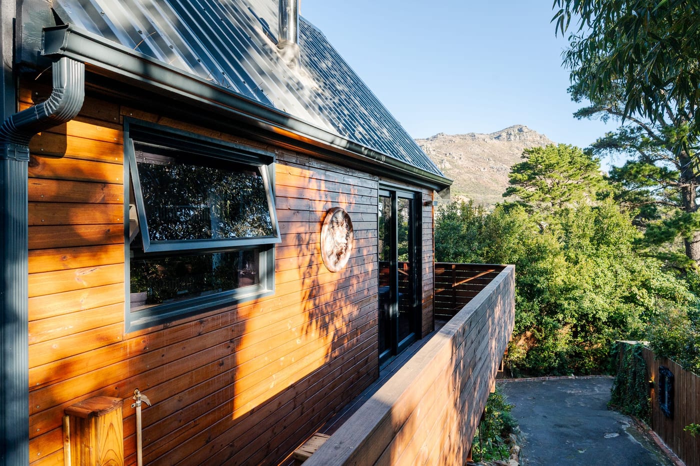 Timber cladding and awning windows, with the Hout Bay ridge beyond
