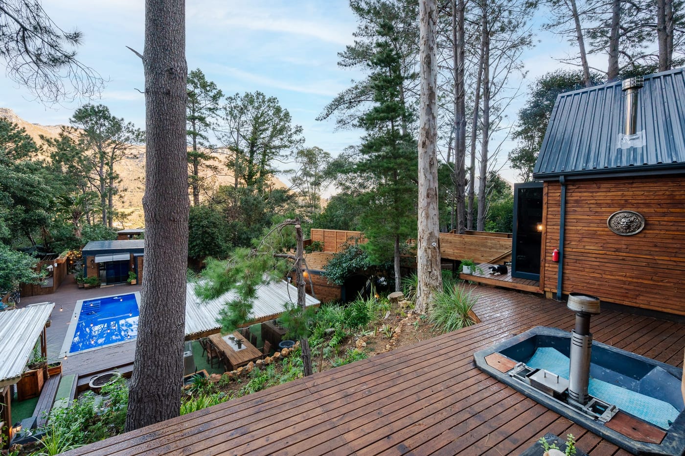 The hot tub set into the upper deck, the pool and pergola below
