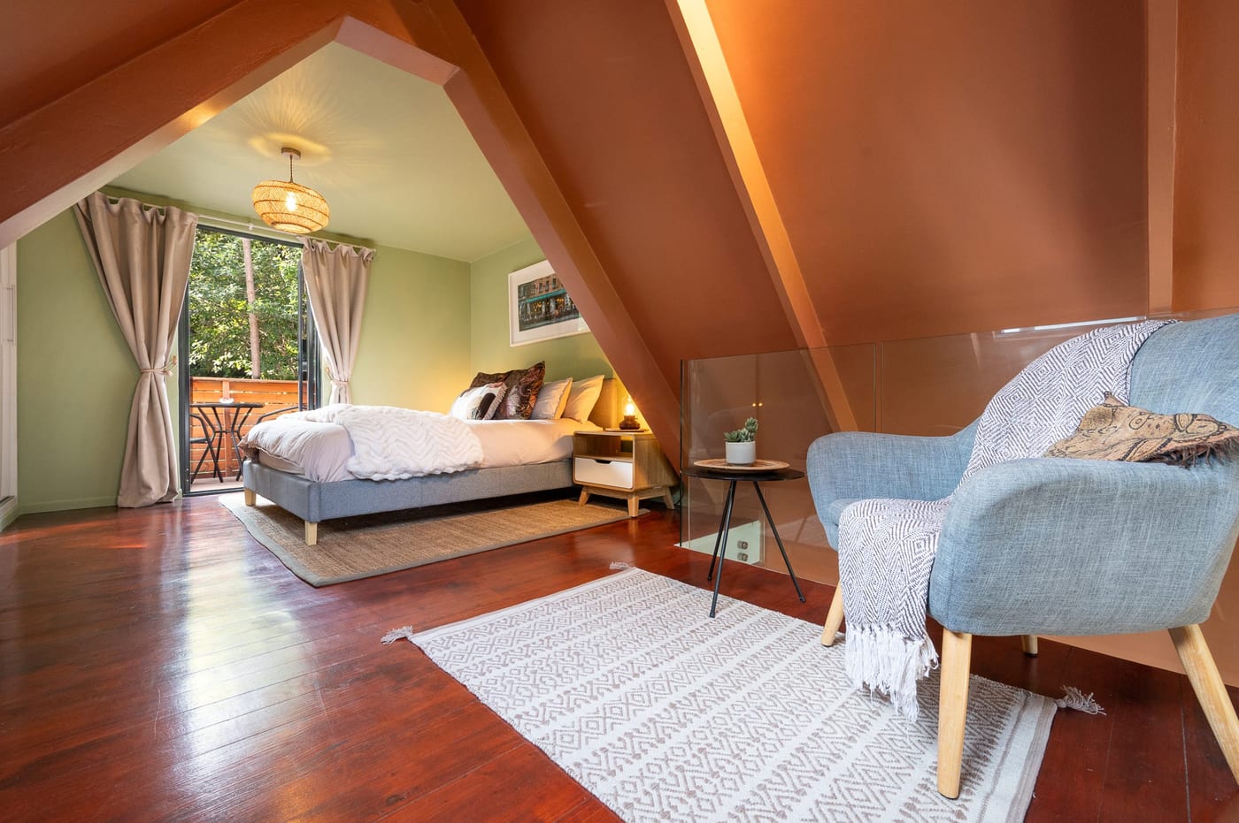 The loft bed seen from the nook, balcony door open to the trees