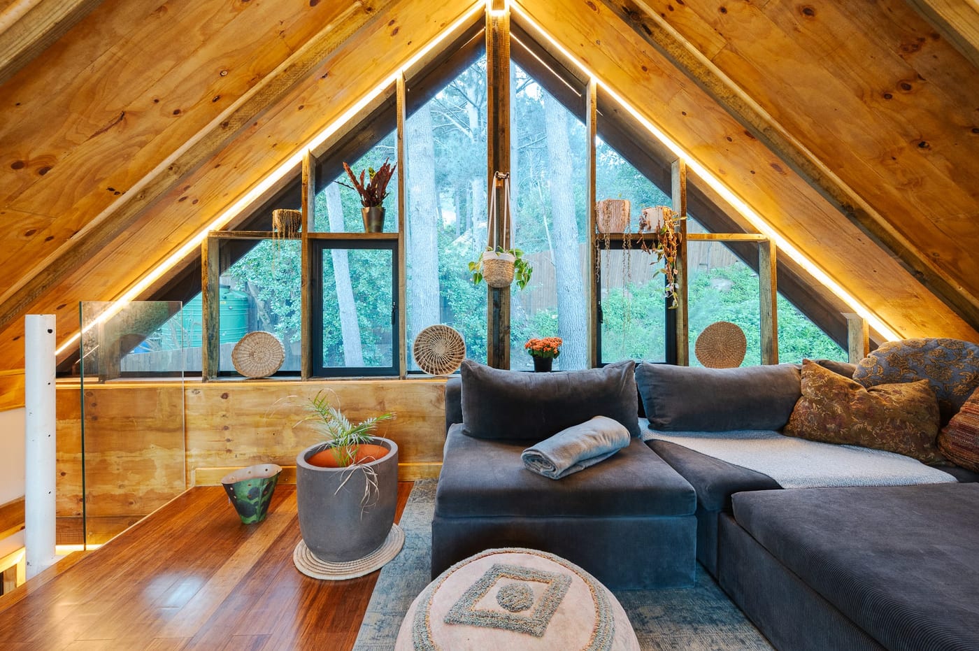 The A-frame loft, its glazed gable looking straight into the pines