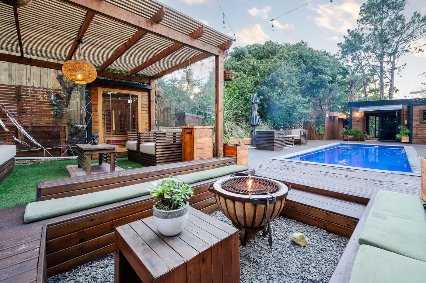The pergola lounge at dusk, sauna and hot tub on one side and the pool on the other