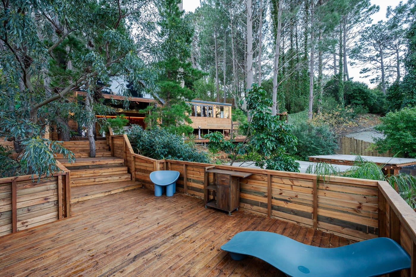 Moulded loungers on the upper sun deck, the cabins beyond through the trees